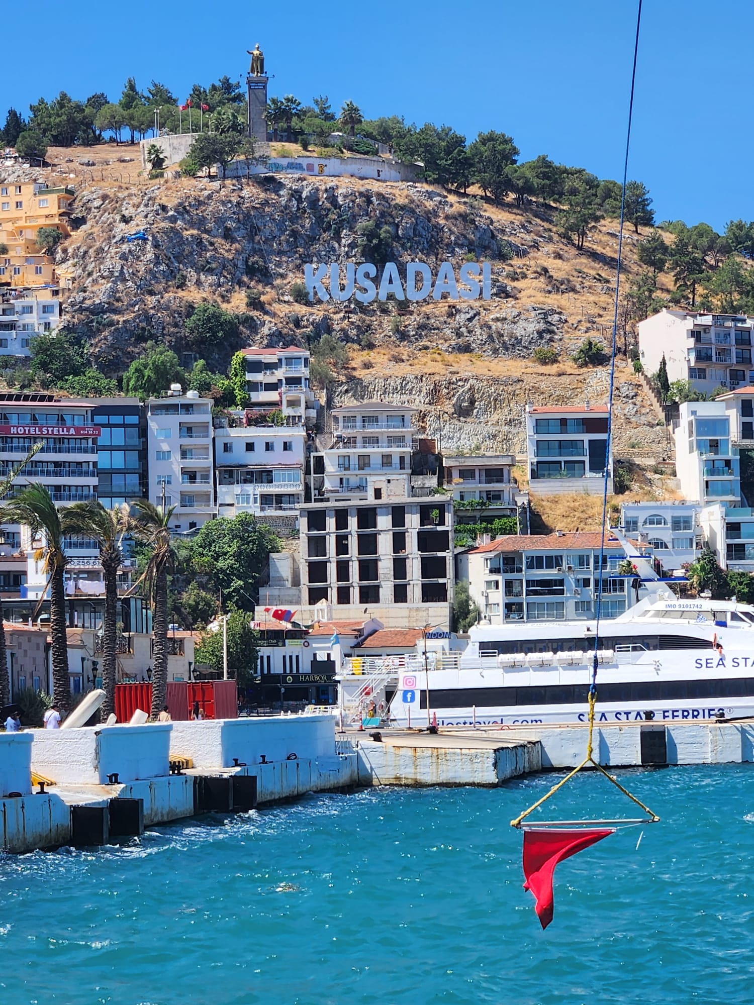 Boats in Kusadasi harbour beside a hillside town