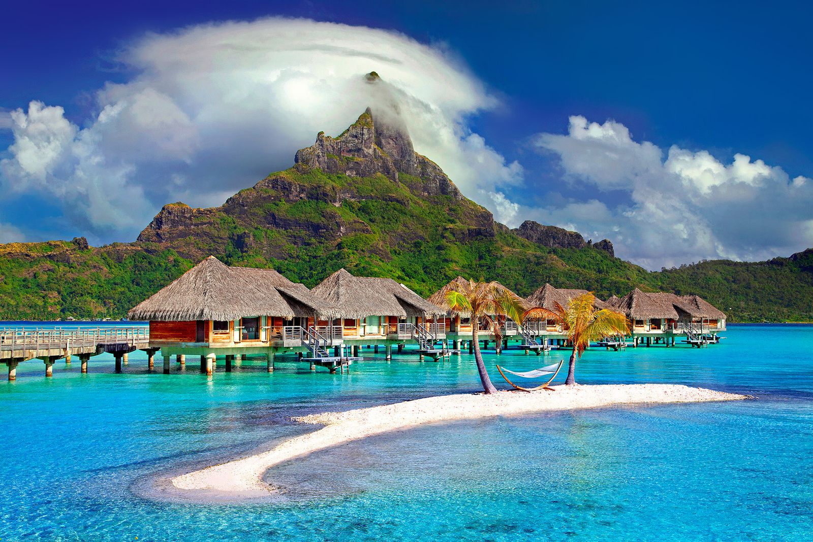 Overwater villas on a calm tropical lagoon at golden hour